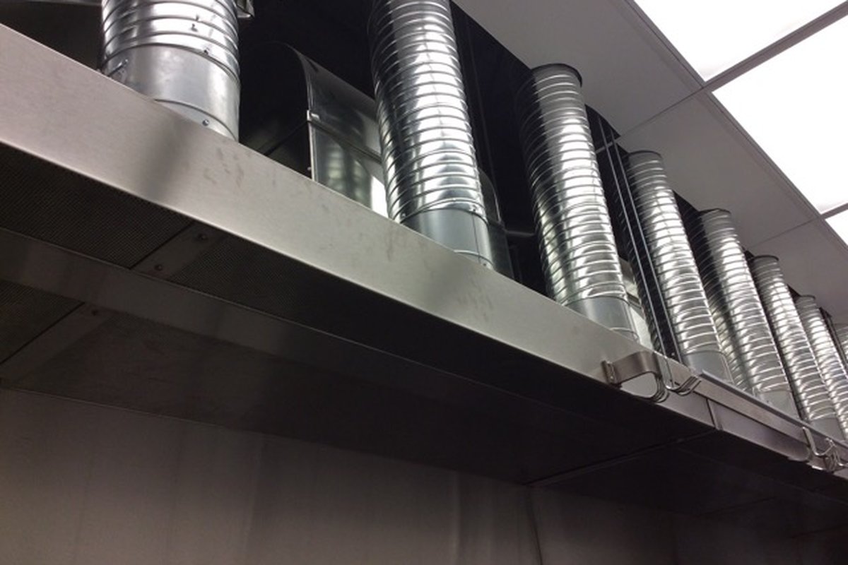 Commercial kitchen exhaust hood over a stainless cooking line